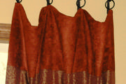 Close up of the banding area of the drapes with sewn on rings hanging on wrought iron hooks from Helser Brothers.
