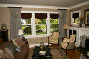 Goblet pleat drapes with toile swags frame the living room windows. 
