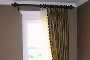 Striped silk drapes with goblet pleats over sheers are mounted on 21/2 inch wood pole.
